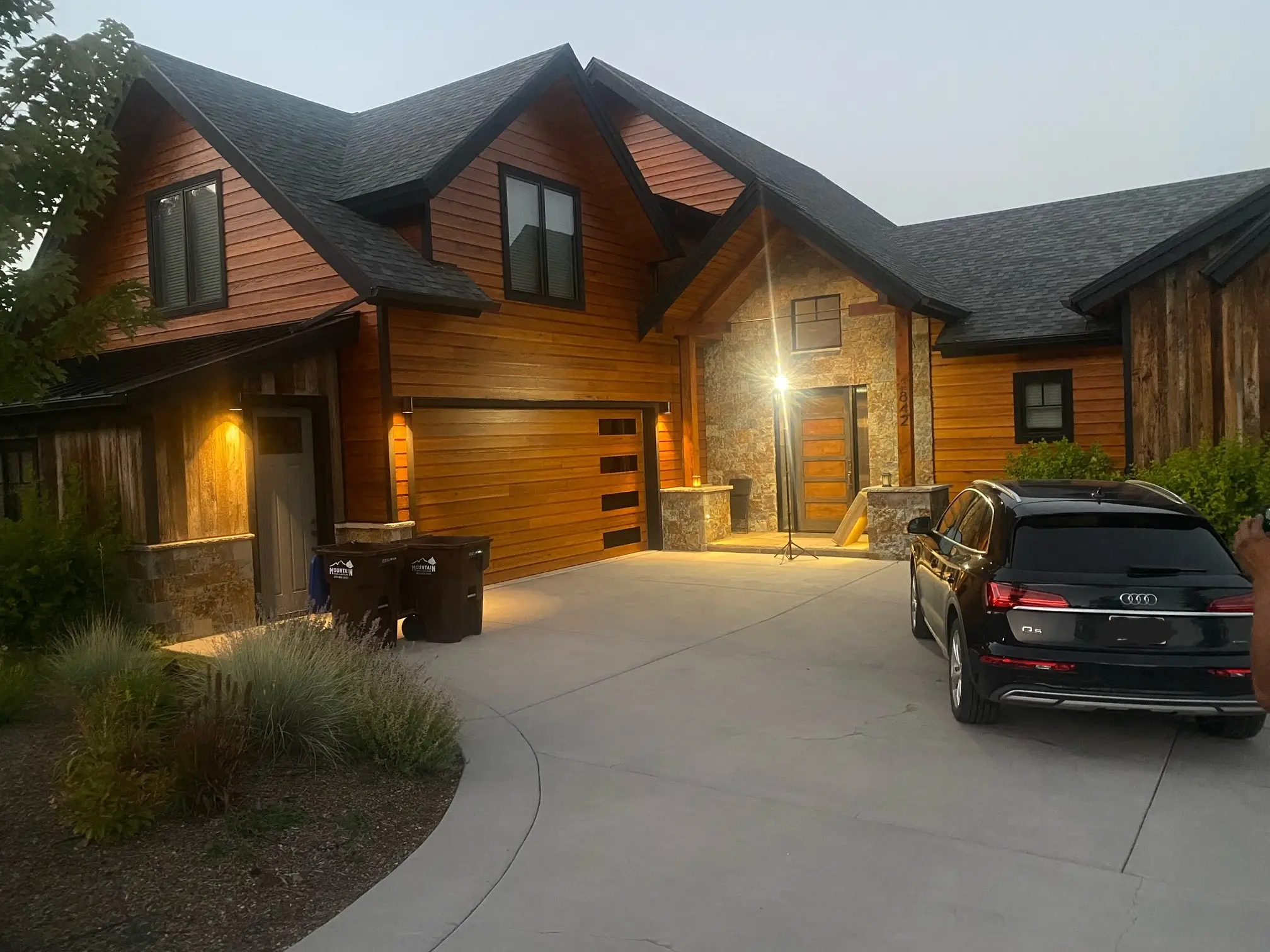 Luxury mountain home exterior with warm cedar wood staining — completed by Alpine Color Craft LLC